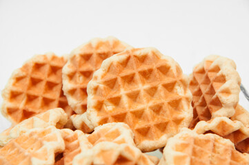 Belgian waffles in a glass bowl. holiday cookies on a white background. fresh baking concept. sweet desserts on a light texture