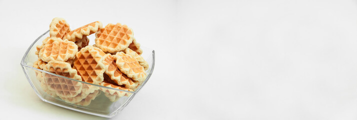 Belgian waffles in a glass bowl. holiday cookies on a white background. fresh baking concept. sweet desserts on a light texture