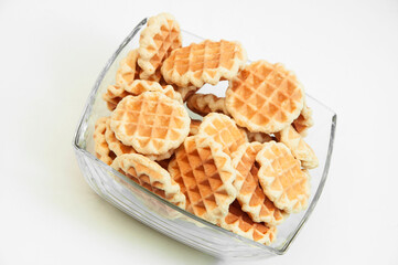 Belgian waffles in a glass bowl. holiday cookies on a white background. fresh baking concept. sweet desserts on a light texture