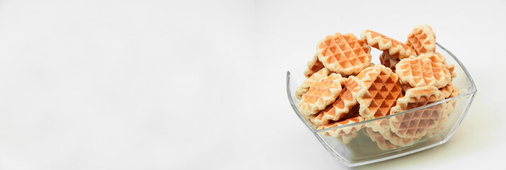 Belgian waffles in a glass bowl. holiday cookies on a white background. fresh baking concept. sweet desserts on a light texture