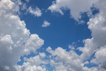 Obraz na płótnie Canvas White cotton-textured clouds on a blue sky background. 