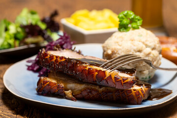 portion of fresh roasted pork on a blue plate