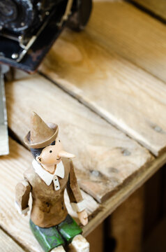 figurine of pinocchio sitting on a wooden table top