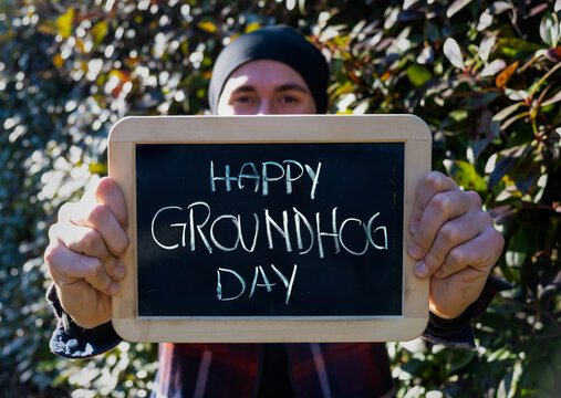 Groundhog day. February 2. Young man holding blackboard with hand written for social content