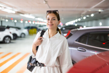 Young elegant business woman walking in the underground parking of a shopping center