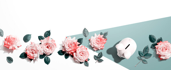 Piggy bank with pink roses overhead view - flat lay