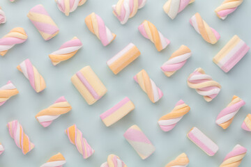 Colorful marshmallow laid out on pastel background. Creative textured pattern.