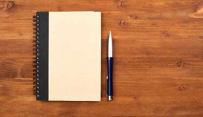 Blank notepad with kraft board cover, spiral and pen.Mockup