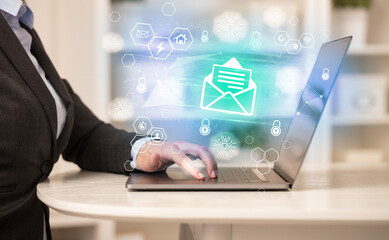 Hands working on laptop with digital icons