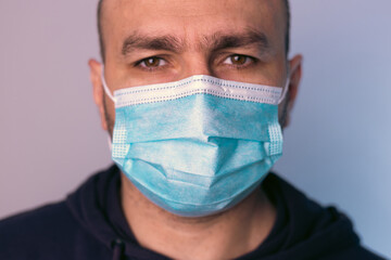 Portrait of a male face in a medical, protective mask against the flu.