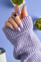 Womans hand with fashionable purple manicure. Spring nail design