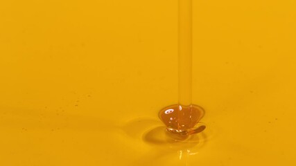 SLOW MOTION MACRO, DOF: Golden liquid falls into a container full of cold pressed extra virgin olive oil. Shiny unrefined avocado oil streams into a full dish. Organically grown cooking ingredient. - Powered by Adobe