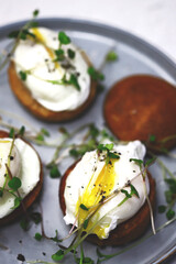 Selective focus. Poached eggs on buns with microgreens on a plate.