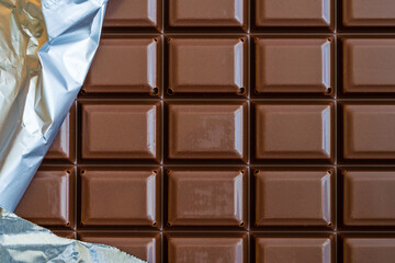 Chocolate bar with part of the silver wrapper.