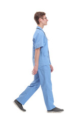 Full length studio shot of walking young male doctor with stethoscope, side view