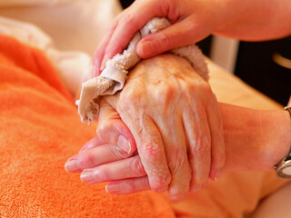 Insights into the home care of relatives in one's own family with dementia. etc. Hands of a dementia patient are held.