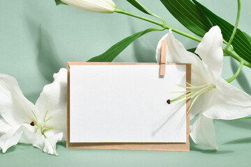 The template is a blank paper and an envelope with space for text on a light green background with lily flowers.