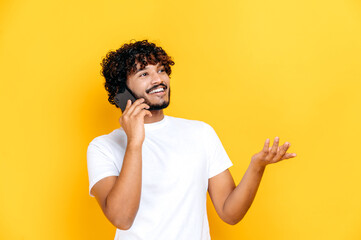 Phone talk by cellphone. Happy joyful excited Indian charismatic guy has a pleasant phone...