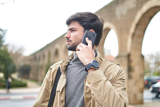 Pensive man having phone call on smartphone