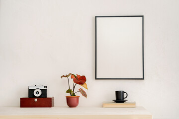 Poster frame, box, books and camera. Stylish home decor design. Mockup