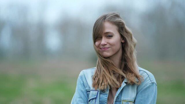 [4k] portrait of young blonde woman pouting in strong wind
