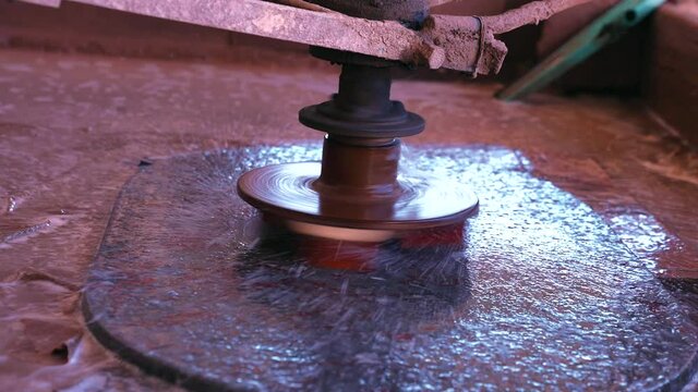 Working of traditional marble machinery. Polishing rocks and ancient archaeological remains. Polishing extinct ammonites nautilus fossil animal shell in stone wall, Polishing extinct shell fossils.