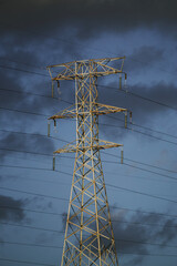 An electrical high voltage tower with dark clouds heralding an electrical storm soon