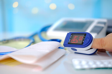 stethoscope, medical device pulse oximeter for measuring oxygen in the blood on a white table,...