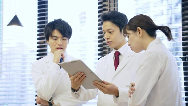 ミーティングする白衣を着た日本人グループ　医師　科学者