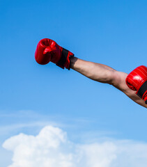 Hand in boxing gloves. Boxing. Sky background. Energy. Strong. Hands. Photo. Sport. Fit