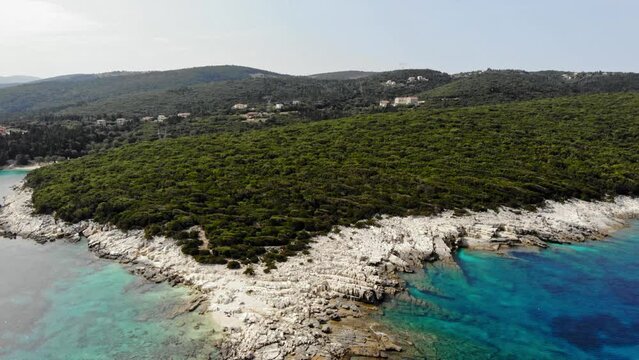 Rocky Coastline With Green Vegetation At Alexia Beach In Erisos, Greece. - aerial pullback