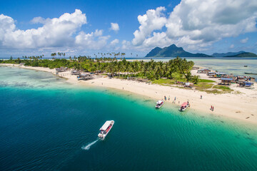 Aerial view of Maiga island panorama, beautiful blue lagoon and coral reef.