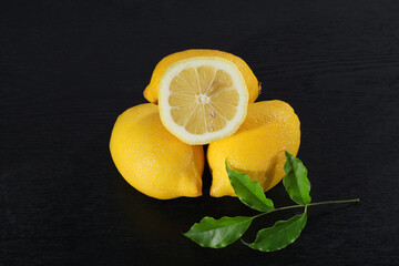 A yellow lemon against a black background.