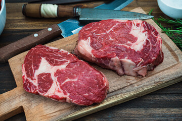 Close-up of two raw Rib Eyes on a rustic wooden cutting board. Food concept. Aerial view.