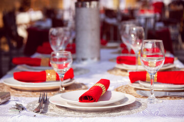 a beautiful decoration made with plates and red scarves along with the glasses