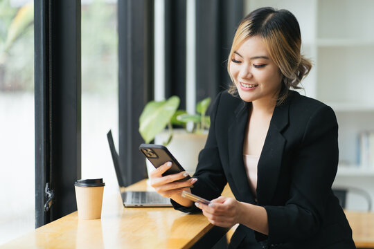 Business people shopping via online application media concept. Happy smile young adult asian woman consumer using creadit card and smartphone.