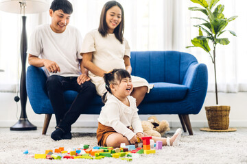 Portrait of enjoy happy love asian family father and mother with little asian girl smiling activity learn and skill brain training play with toy build wooden blocks board education game at home
