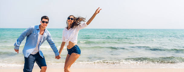 Vacation romantic love young happy smile couple in honeymoon travel holiday trip standing on sand at blue sky sea beach having fun and relaxing together on tropical beach.Summer travel