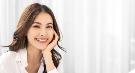 Portrait of smiling cheerful beautiful pretty asian woman clean fresh healthy white skin posing smile in pajamas white clothes.Girl felling relax and enjoy time on the bed at home.asia beauty