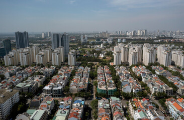Sunny day aerial view of modern city real estate development with terrace houses, villas and high rise buildings with green space