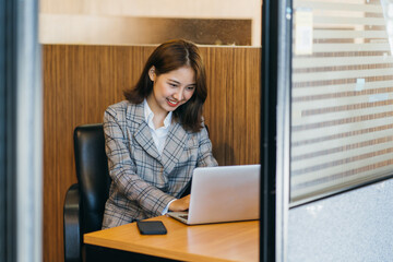 Naklejka premium Asian woman working on a laptop computer,Working in the office with laptop concept,Young Asian woman starting a business using a laptop computer.
