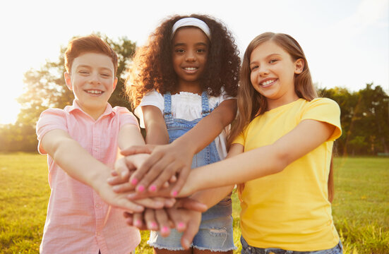 Group of diverse kids stacking hands together