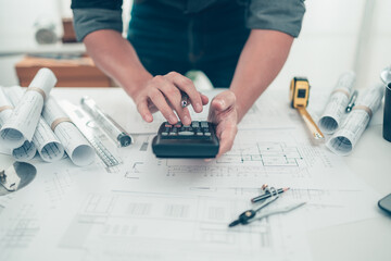 Architect engineer use calculator for calculate drawing design working on bueprint. House planning...