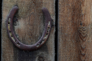 Rusty horseshoe nailed to an old barn wall.