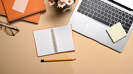 Top view creative workspace with notebook, glasses and computer laptop.