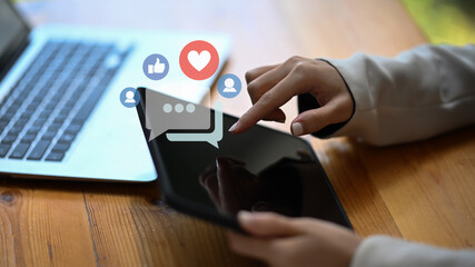 Woman using digital tablet for sharing and commenting in the online community.