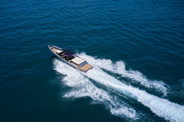 Dark gray blue boat in motion at sea. Boat drone view. Speedboat moving fast on blue water aerial view.