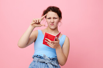 teenager girl in a blue T-shirt with a red notepad and a pen of emotions isolated background unaltered