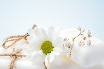 Soap bars with flowers on white surface