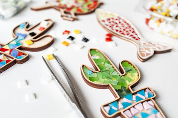 Multi-colored glass and wooden molds in the form of cactus, fish for mosaic, handicrafts